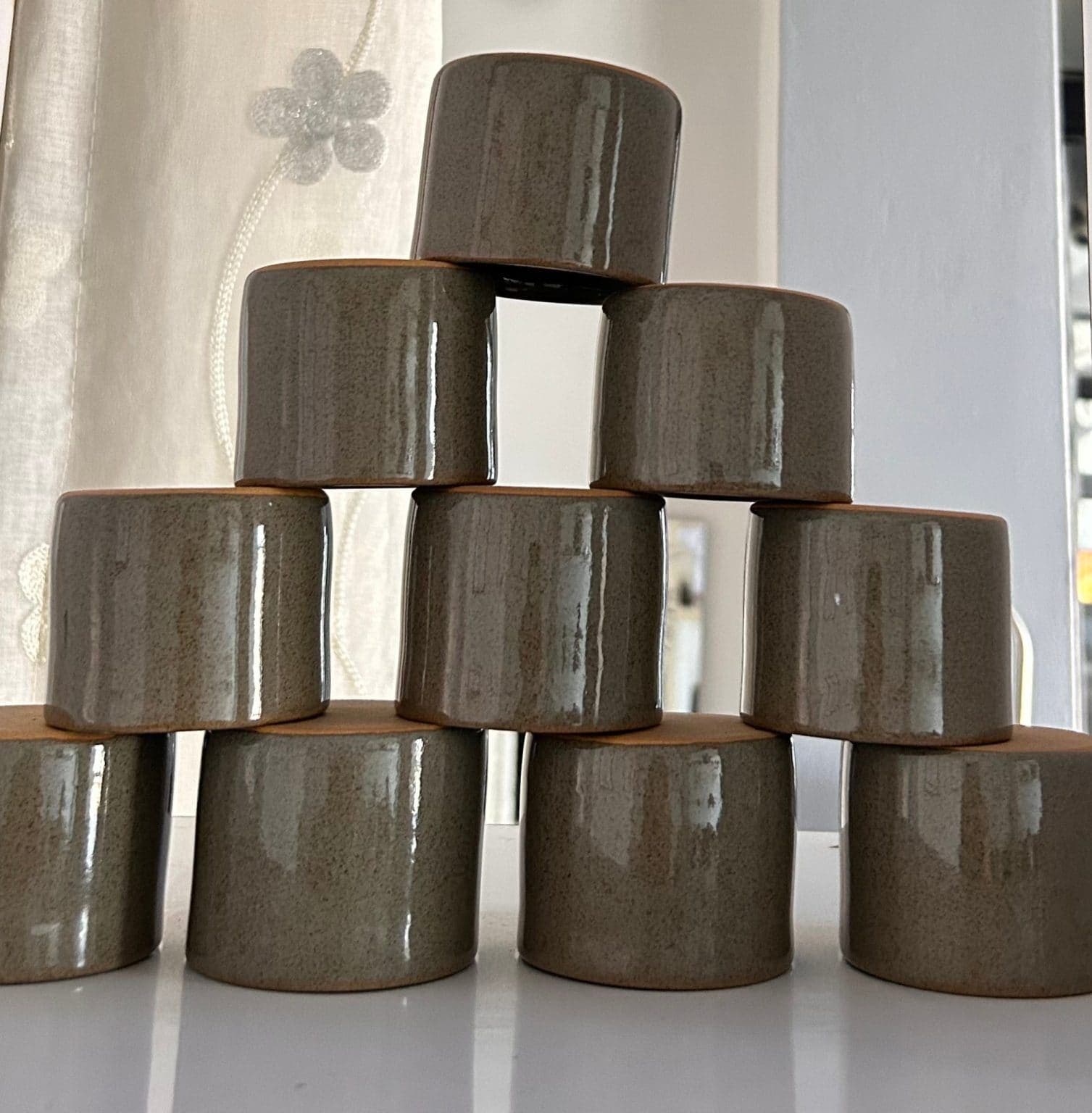 Bicchieri cilindrici scuri impilati a piramide.