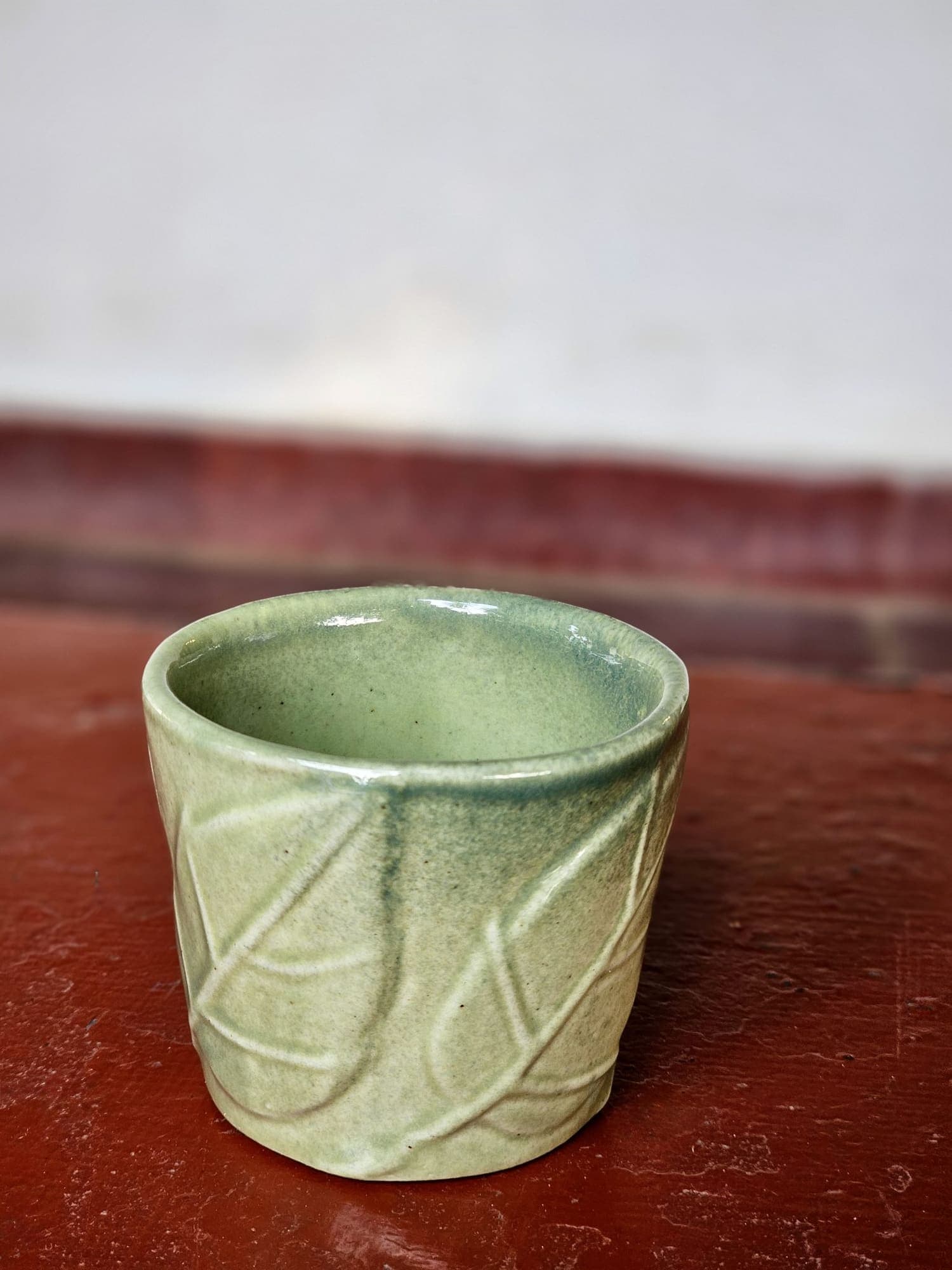 Tazza senza manico in celadon verde chiaro con decoro inciso a foglie.